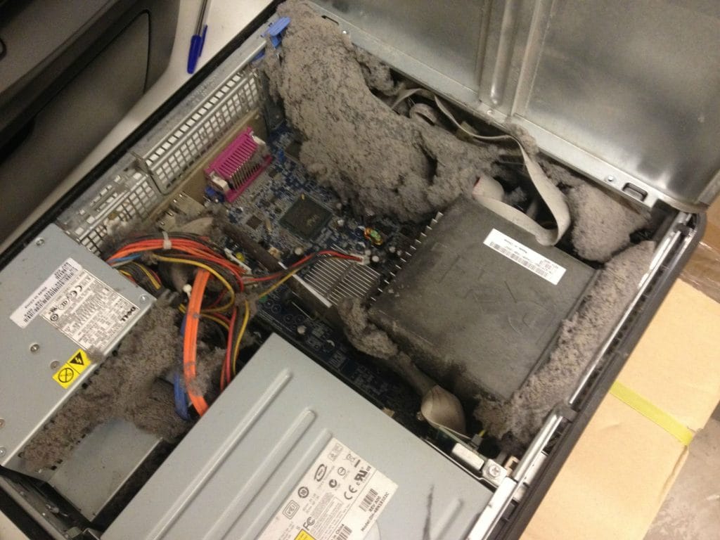 Thick mat of dust completely blocking the cooling vents inside a desktop computer case. A stark reminder to clean your tech and ensure proper airflow